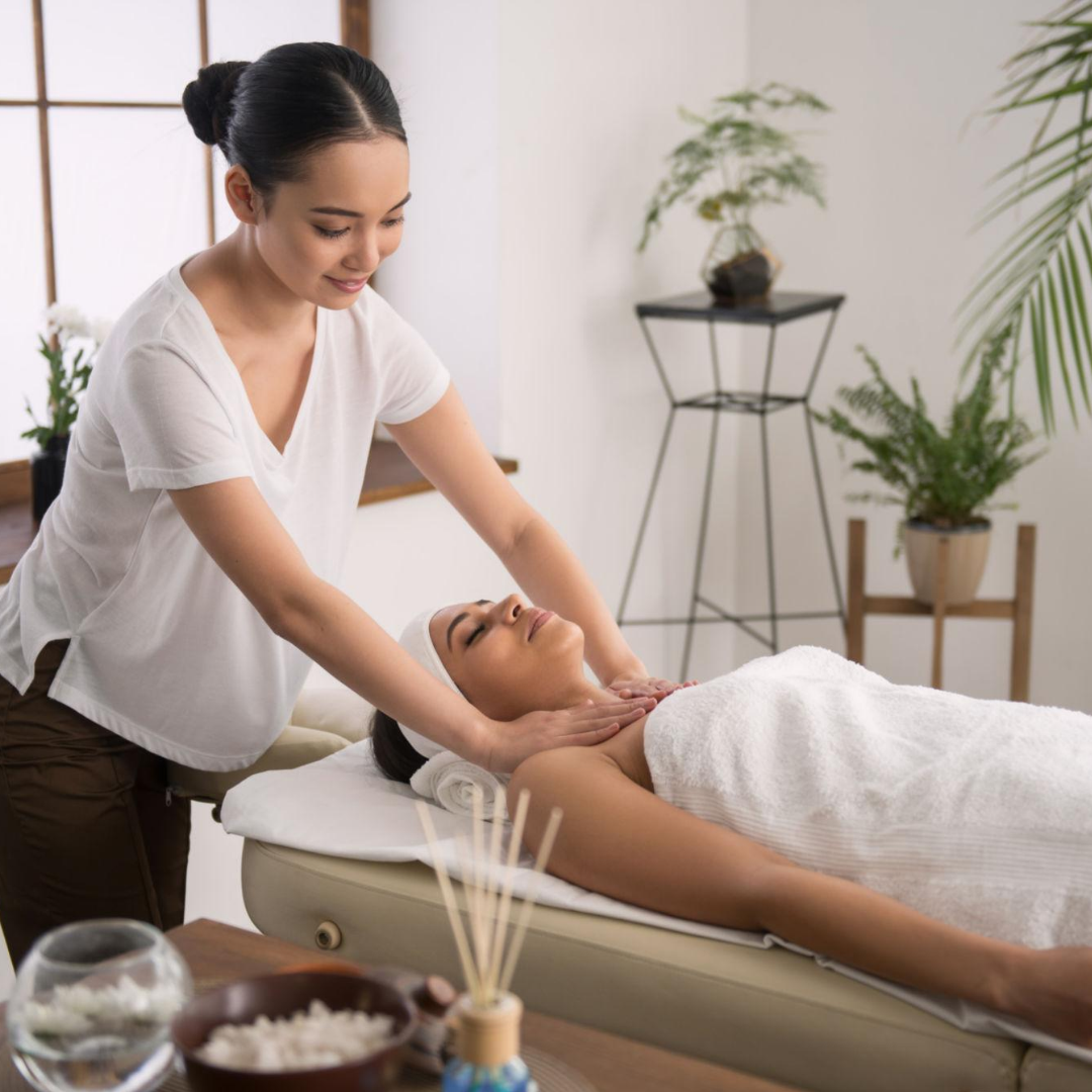 Aromatherapy massage treatment with a towel-covered client at a spa